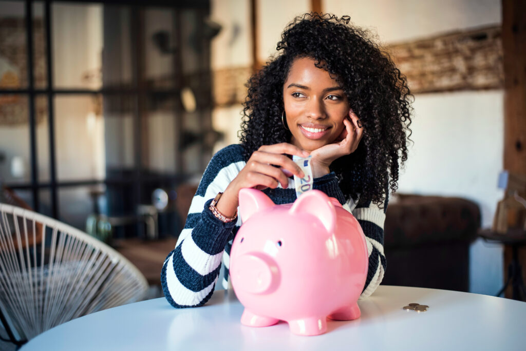 Black woman with saving piggy bank